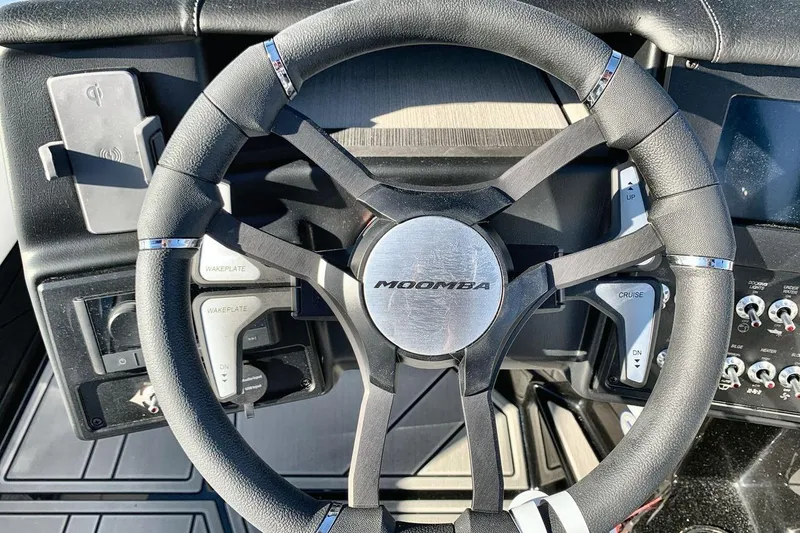 Slide: The Image of Steering wheel of 2026 Moomba Mojo boat with control buttons and sleek design. - 14