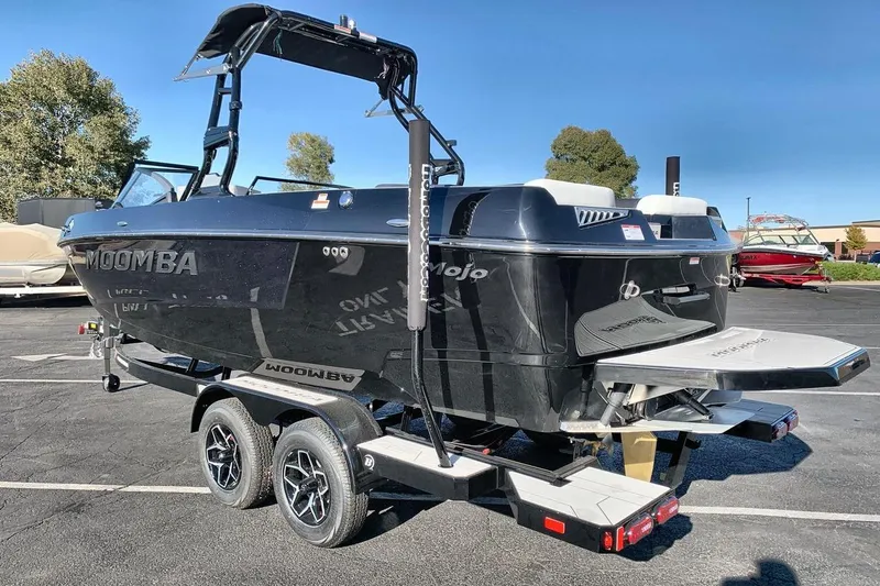 Slide: The Image of 2026 Moomba Mojo boat on trailer, sleek black design, parked outdoors. - 3