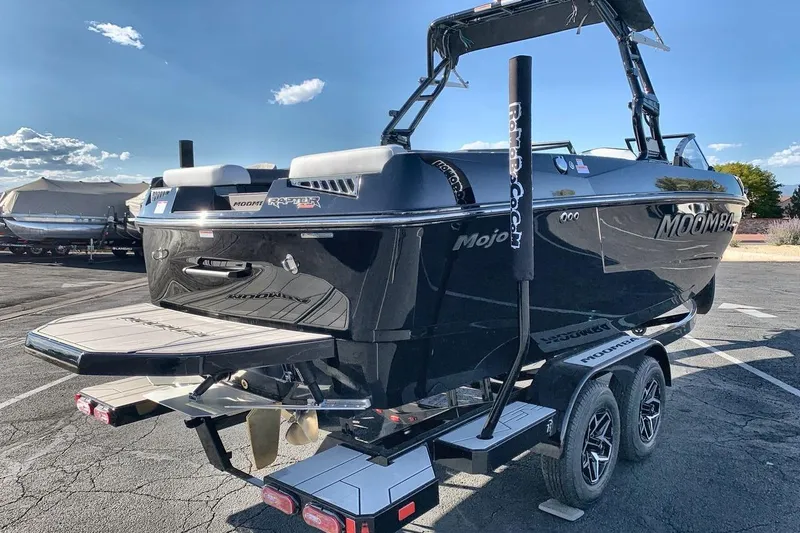 Slide: The Image of 2026 Moomba Mojo boat on trailer, sleek black design under clear sky. - 5