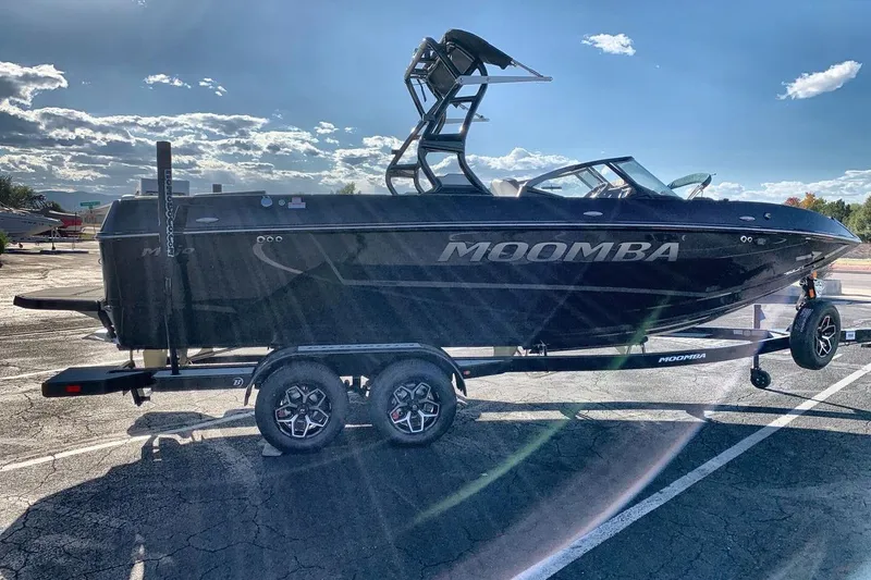 Slide: The Image of 2026 Moomba Mojo boat on trailer under clear sky, showcasing sleek design. - 6