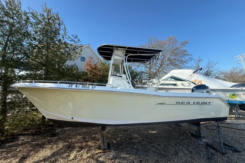 The Image of 2007 Sea Hunt Triton 220 boat on display, parked on gravel with trees in background. - 0
