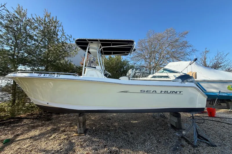 Slide: The Image of 2007 Sea Hunt Triton 220 boat on stands, surrounded by trees and clear blue sky. - 5