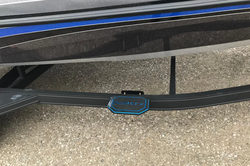 Slide: The Image of 2022 Ranger Z185 boat trailer with BoatEFX step on gravel surface. - 13