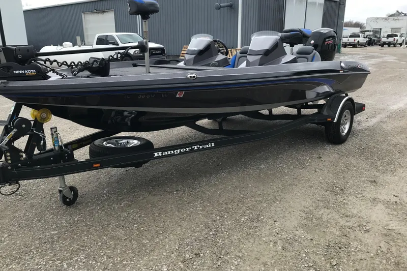 Slide: The Image of 2022 Ranger Z185 boat on trailer, parked outdoors near industrial buildings. - 14