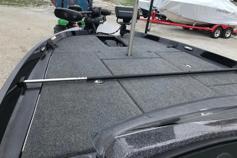 Slide: The Image of 2022 Ranger Z185 boat deck with fishing rod and equipment, parked on gravel. - 35