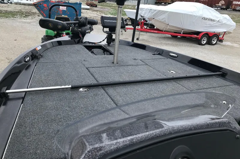 Slide: The Image of 2022 Ranger Z185 boat deck with fishing equipment and covered boat in background. - 36