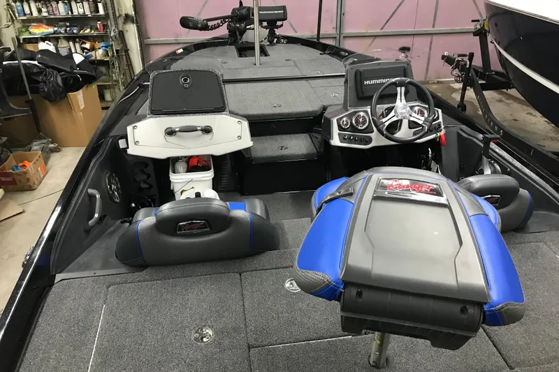 Slide: The Image of 2022 Ranger Z185 boat interior with steering wheel, seats, and control panel in a garage. - 41