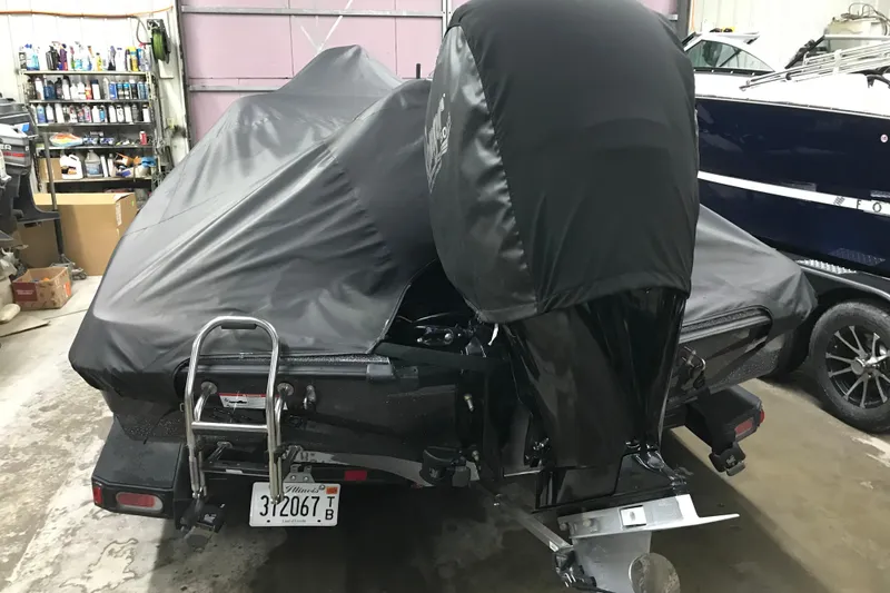 Slide: The Image of 2022 Ranger Z185 boat covered in a garage, showcasing rear view and motor. - 42