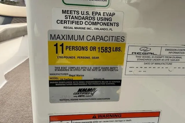 Slide: The Image of 2012 Regal 24 FasDeck capacity label, 11 persons or 1583 lbs, safety compliance details. - 10