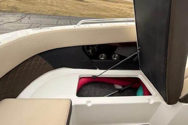 Slide: The Image of 2012 Regal 24 FasDeck boat interior storage compartment with cup holders and seating. - 17