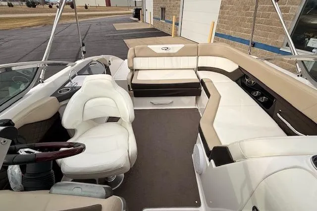 Slide: The Image of 2012 Regal 24 FasDeck boat interior with white and beige seating, steering wheel, and dashboard. - 18