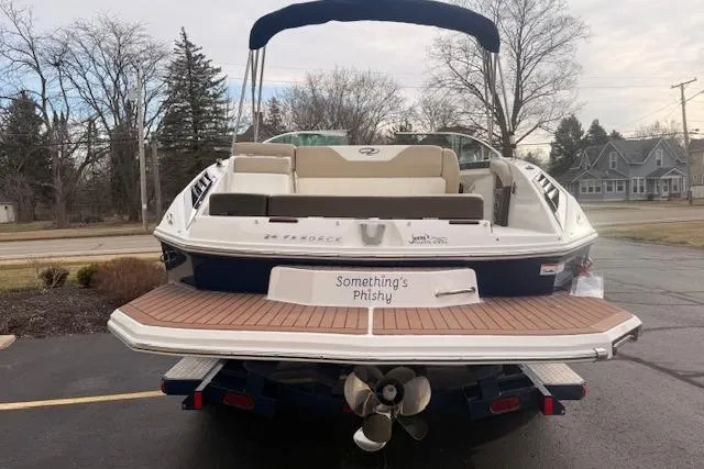 Slide: The Image of 2012 Regal 24 FasDeck boat with "Something's Phishy" name, parked on a driveway. - 2
