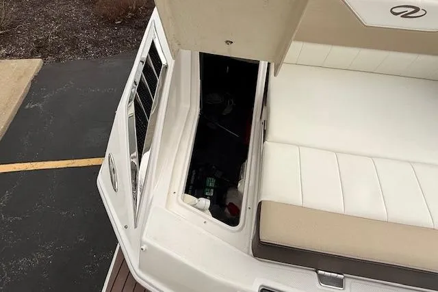 Slide: The Image of 2012 Regal 24 FasDeck boat with open storage compartment and white seating. - 23