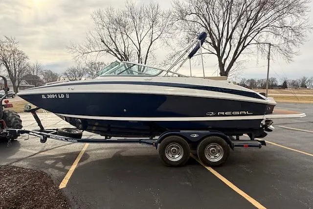 Slide: The Image of 2012 Regal 24 FasDeck boat on trailer in parking lot, overcast sky. - 3