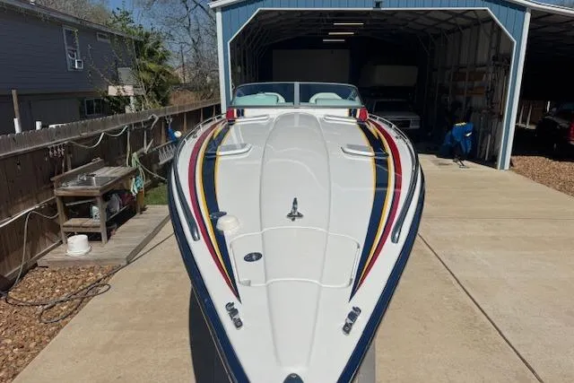 Slide: The Image of 2007 Formula 353 FASTech boat with colorful stripes, parked in a driveway near a garage. - 6