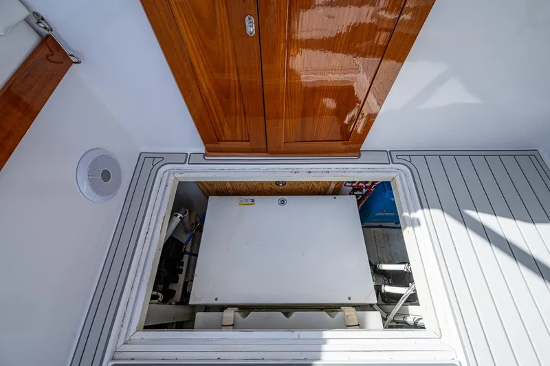 Slide: The Image of 2019 Custom Carolina Custom Express engine compartment with wooden hatch and sleek interior design. - 22