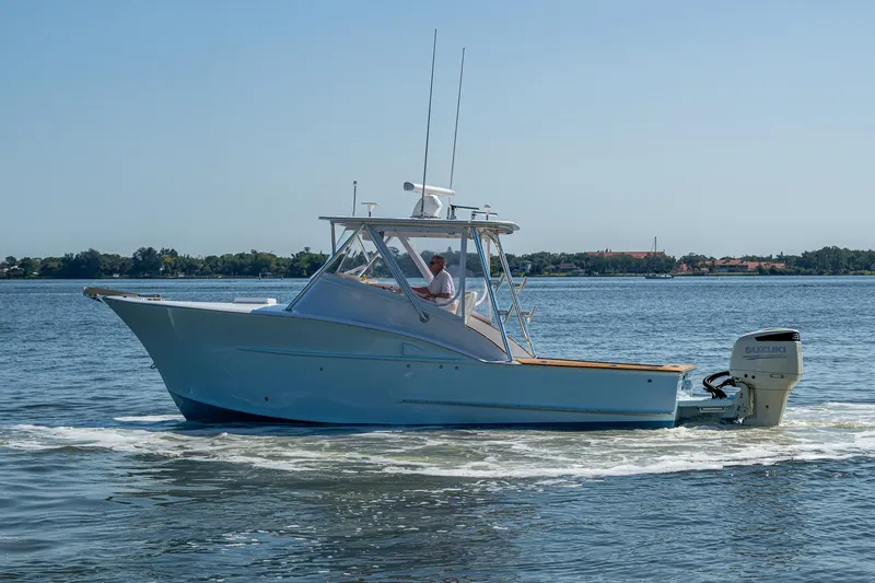 Slide: The Image of 2019 Custom Carolina Custom Express boat cruising on calm waters. - 33