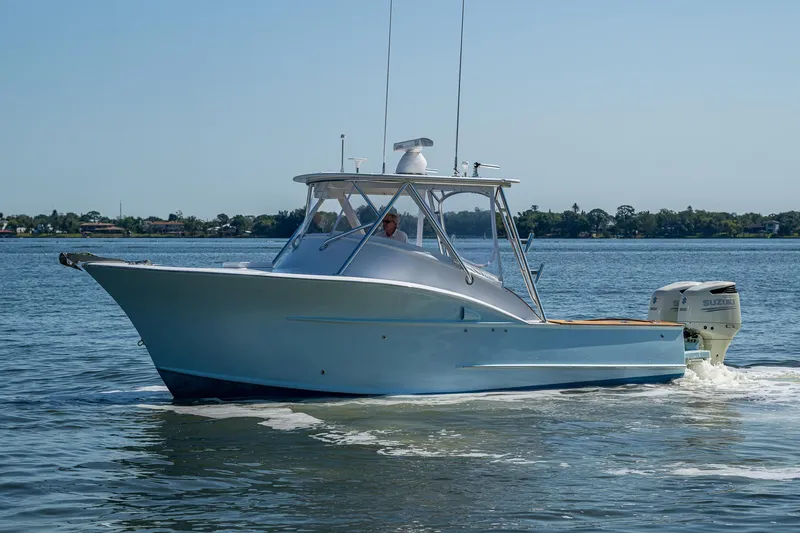 Slide: The Image of 2019 Custom Carolina Custom Express boat cruising on calm waters. - 34