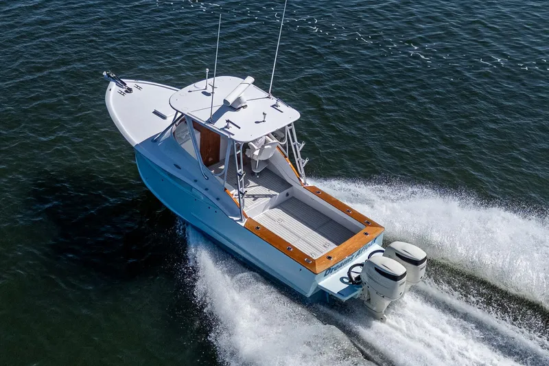 Slide: The Image of 2019 Custom Carolina Custom Express boat cruising on open water, rear view. - 4