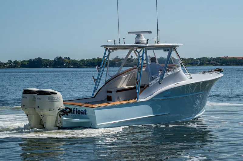 Slide: The Image of 2019 Custom Carolina Custom Express boat cruising on a calm lake. - 40