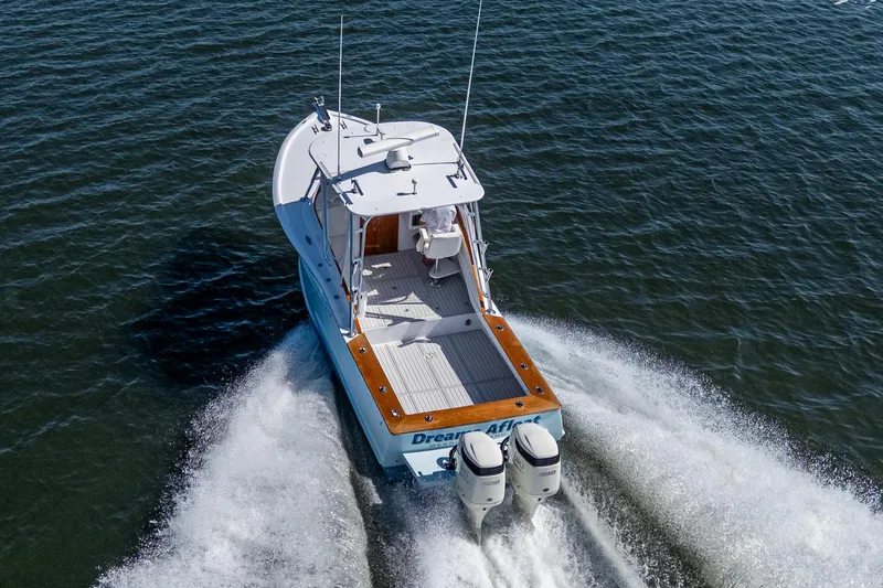 Slide: The Image of 2019 Custom Carolina Custom Express boat cruising on open water, rear view. - 7