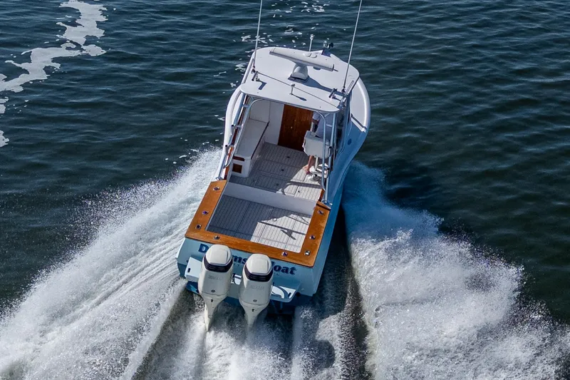 Slide: The Image of 2019 Custom Carolina Custom Express boat cruising on open water, rear view. - 9