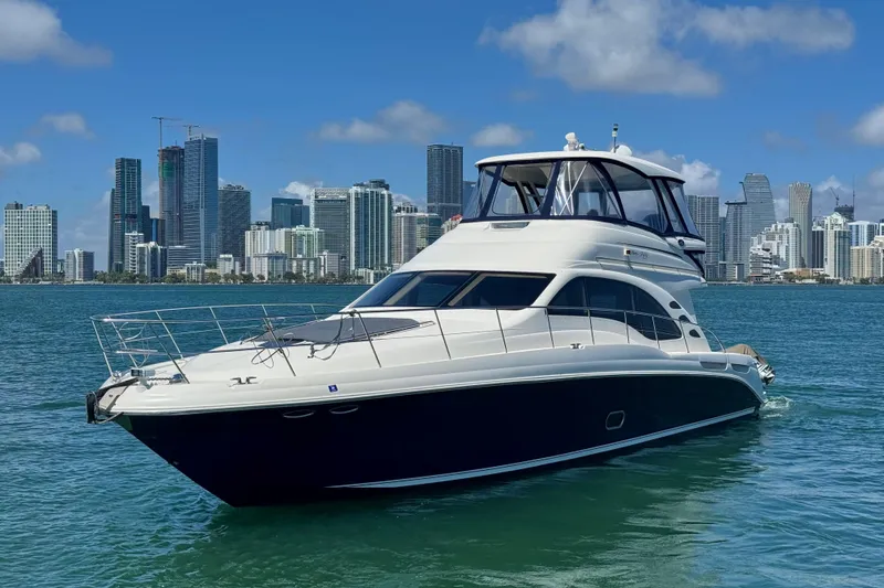 The Image of 2005 Sea Ray 550 Sedan Bridge yacht cruising near city skyline on a sunny day. - 0