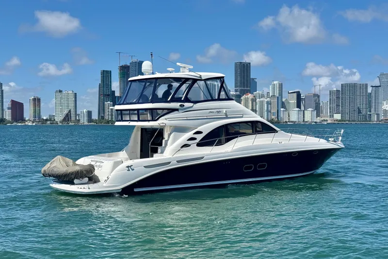 Slide: The Image of 2005 Sea Ray 550 Sedan Bridge yacht cruising near city skyline. - 10