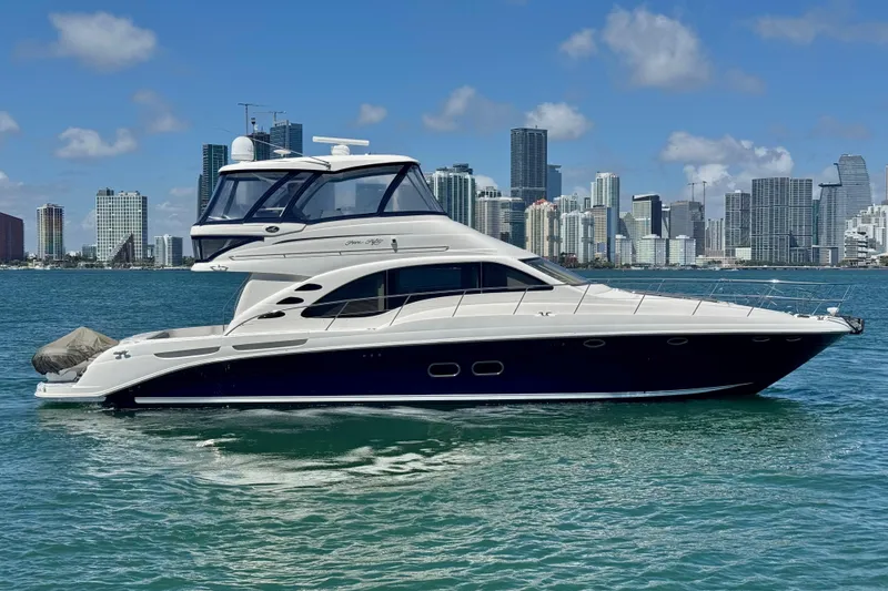 Slide: The Image of 2005 Sea Ray 550 Sedan Bridge yacht on water with city skyline background. - 11