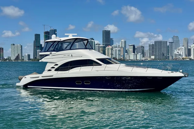 Slide: The Image of 2005 Sea Ray 550 Sedan Bridge yacht cruising near city skyline on a sunny day. - 12