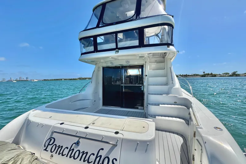 Slide: The Image of 2005 Sea Ray 550 Sedan Bridge yacht on clear blue water, rear view with stairs and deck. - 17