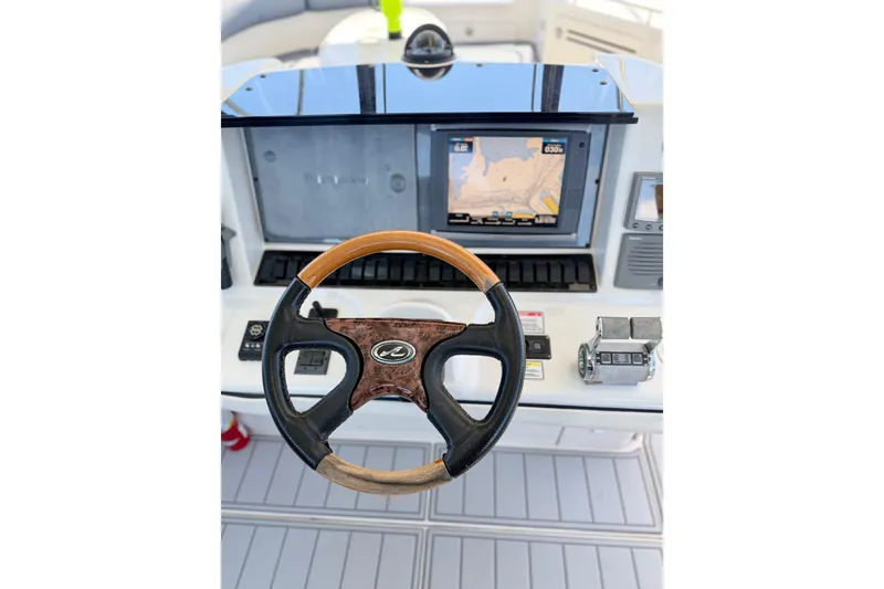 Slide: The Image of 2005 Sea Ray 550 Sedan Bridge helm with navigation display and steering wheel. - 19