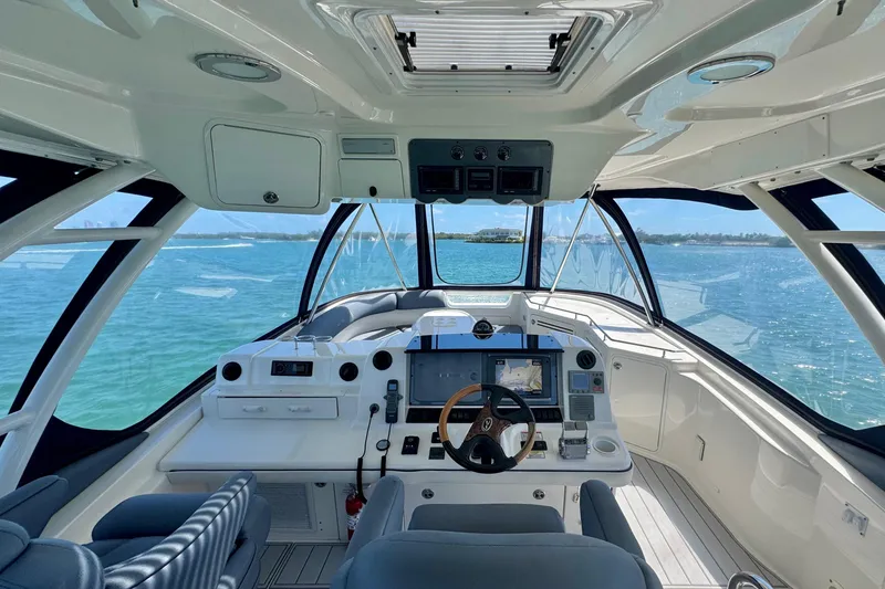 Slide: The Image of 2005 Sea Ray 550 Sedan Bridge helm with panoramic ocean view and modern navigation equipment. - 2