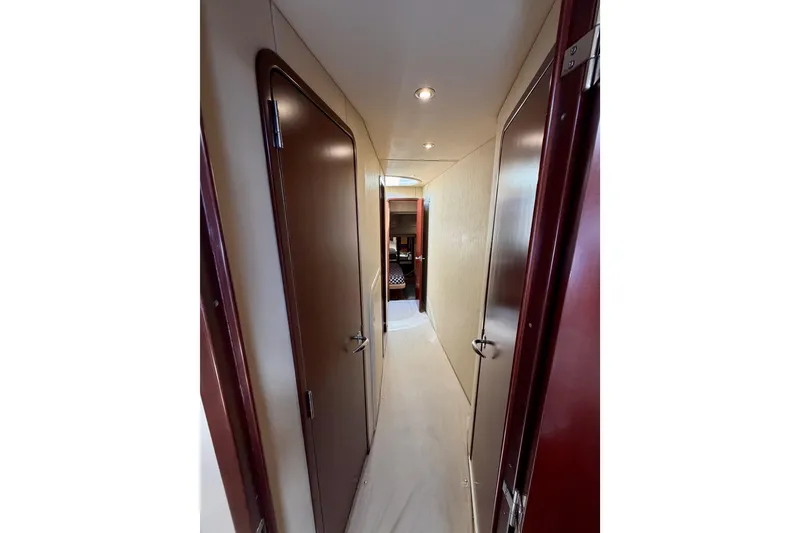 Slide: The Image of Hallway inside 2005 Sea Ray 550 Sedan Bridge yacht, featuring wooden doors and modern lighting. - 30