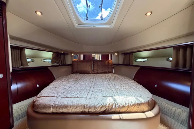 Slide: The Image of Luxurious 2005 Sea Ray 550 Sedan Bridge cabin interior with plush bedding and elegant wood finishes. - 31