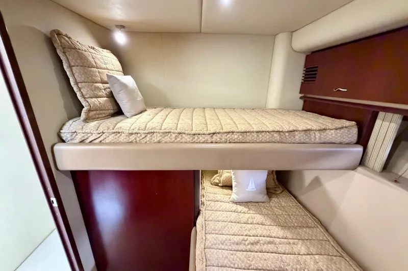 Slide: The Image of Bunk beds in 2005 Sea Ray 550 Sedan Bridge yacht cabin, featuring beige bedding. - 33