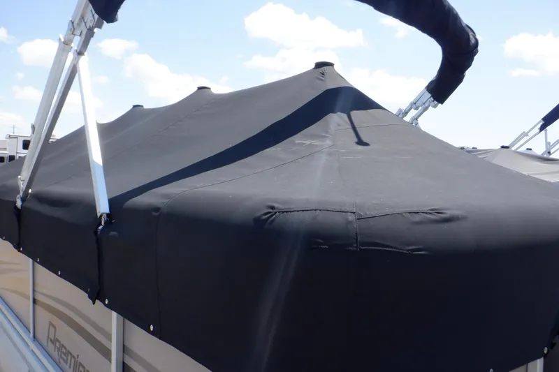 Slide: The Image of 2009 Premier 225 Sunsation LTD boat with black cover under a clear sky. - 15