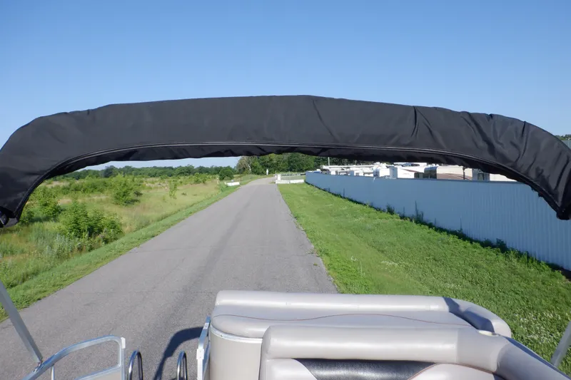 Slide: The Image of 2009 Premier 225 Sunsation LTD boat with black canopy on a rural road. - 38