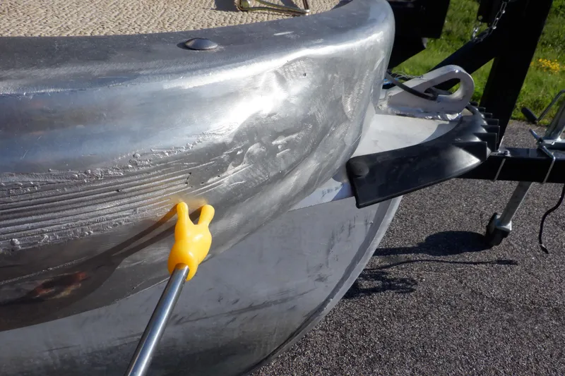 Slide: The Image of 2009 Premier 225 Sunsation LTD boat with visible hull damage and repair tool. - 45