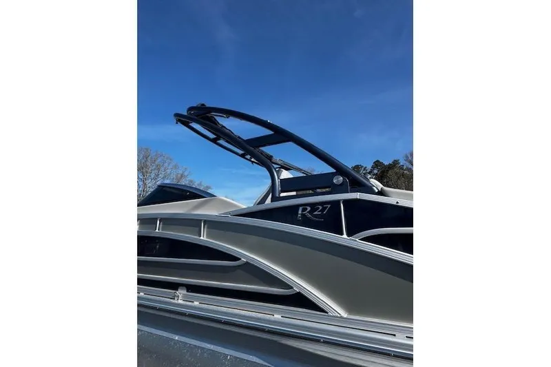 Slide: The Image of 2023 Bennington 27 RSBWA T2 pontoon boat against clear blue sky. - 20