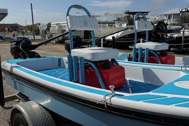 Slide: The Image of 2019 American Marine H:Skiff H13 boat with blue and white design, docked outdoors. - 3
