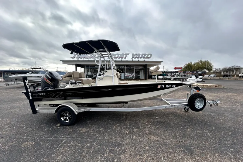 The Image of 2022 Xpress H20B Bay boat on trailer at dealership, overcast sky. - 0