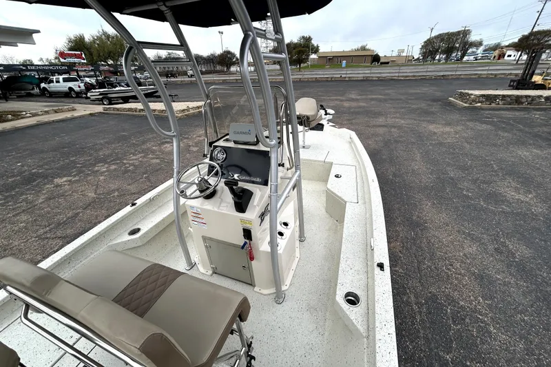 Slide: The Image of 2022 Xpress H20B Bay boat with steering console and seating, parked outdoors. - 11