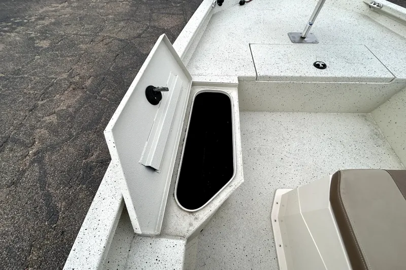 Slide: The Image of 2022 Xpress H20B Bay boat with open storage compartment on speckled deck. - 16