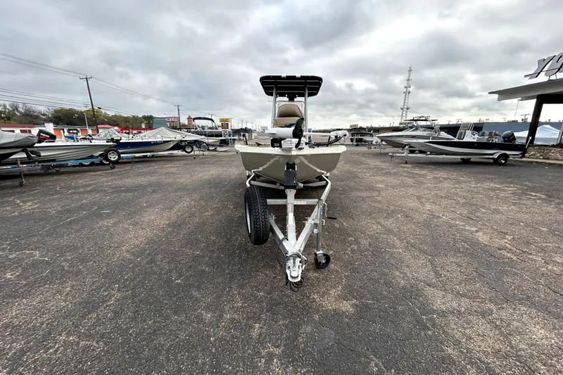 Slide: The Image of 2022 Xpress H20B Bay boat on trailer in dealership lot, cloudy sky background. - 2