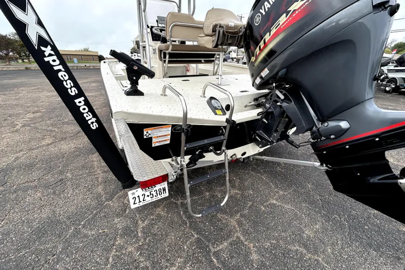 Slide: The Image of 2022 Xpress H20B Bay boat with Yamaha engine and ladder, parked on asphalt. - 9