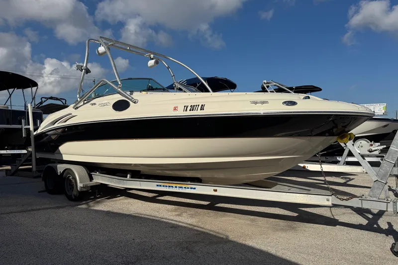 The Image of 2004 Sea Ray 240 Sundeck boat on trailer under blue sky. - 1