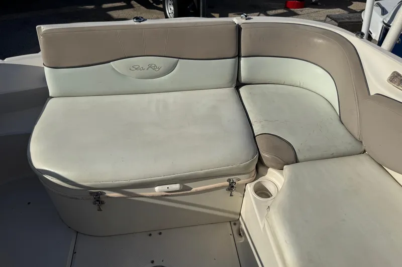 Slide: The Image of 2004 Sea Ray 240 Sundeck boat seating area with beige and white upholstery. - 10
