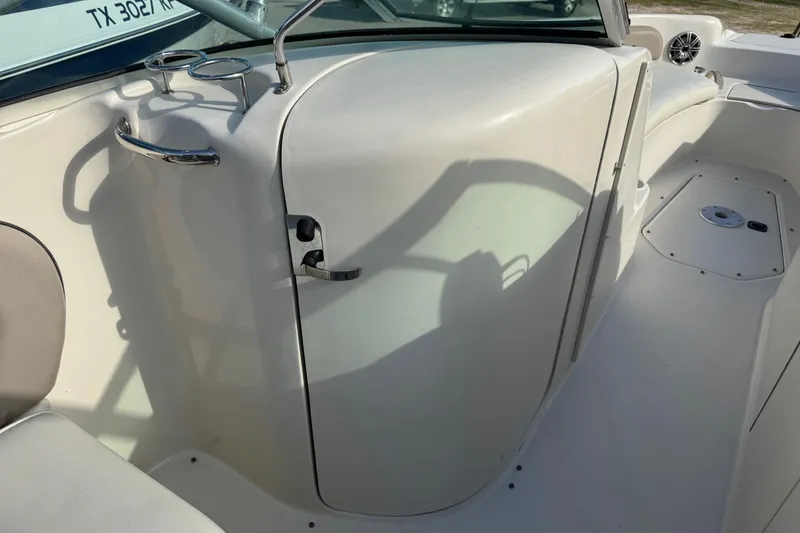 Slide: The Image of 2004 Sea Ray 240 Sundeck interior with cup holders and seating area. - 20