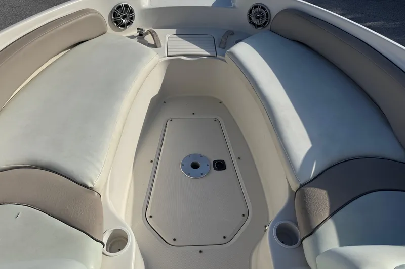 Slide: The Image of 2004 Sea Ray 240 Sundeck boat interior with cushioned seating and cup holders. - 21